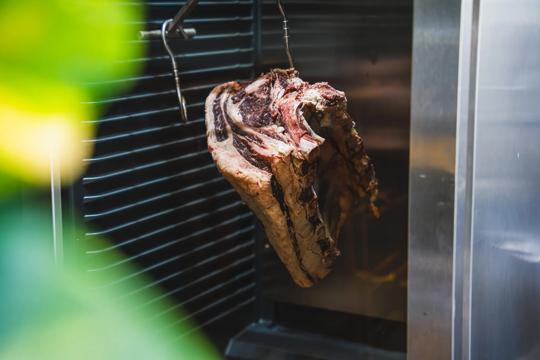 Ein Dry-Aged-Rinderrücken hängt im Reifeschrank.